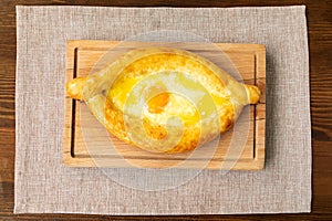 Homemade Ajarian Khachapuri with Sulguni Cheese Filled with a Raw Egg and Melted Butter Close Up.