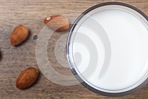 Homemade almond milk with almond on a wooden table