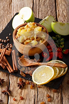 Homemade apple chutney with raisins and spices close-up in a bow