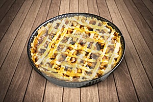 Homemade apple pie with baking dish on table