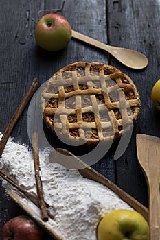 Homemade Apple pie with cinnamon on an old textured wooden background