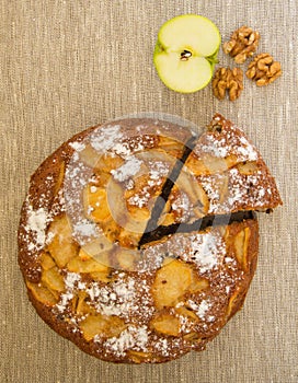 Homemade apple pie, a piece of apple and nuts.Top view