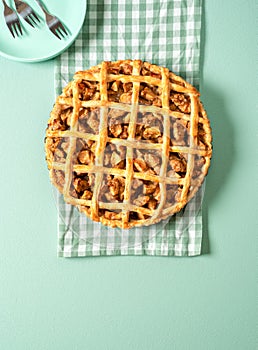 Homemade apple pie top view on green table. Delicious apple cake