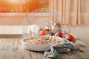 Homemade apple pie on a white wooden background near the window close-up and copy space. Charlotte in the morning on the table