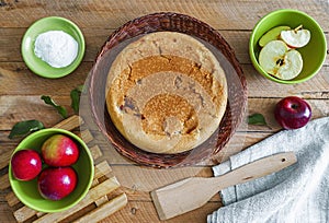 Homemade apple pie in a wicker plate on a wooden table