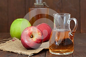 Homemade Apple vinegar in a bottle and a jar with red and green apples