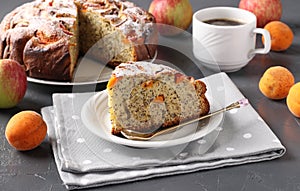 Homemade apricots pie with poppy seeds and apples, with cup of coffee on gray background