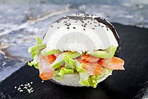 Homemade asian style gluten free sushi salmon burger. Sushi-food hybrids trend. Bright blue background with copy space.