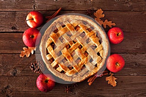 Homemade autumn apple pie, top view with frame of ingredients over rustic wood