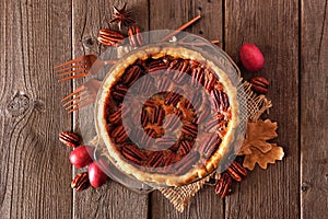 Homemade autumn pecan pie, top view with frame of ingredients over rustic wood