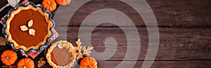 Homemade autumn pumpkin pies corner border on a dark rustic wood banner background