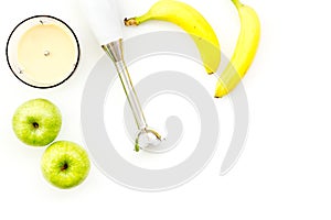 Homemade baby food. Cook puree with apple and banana with immersion blender. White background with toy top view space