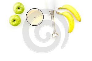 Homemade baby food. Cook puree with apple and banana with immersion blender. White background with toy top view space