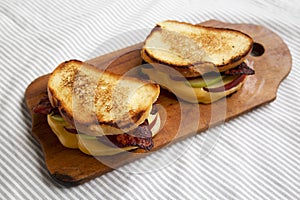 Homemade Bacon Apple Grilled Cheese on a rustic wooden board, low angle view