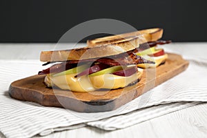 Homemade Bacon Apple Grilled Cheese on a rustic wooden board, side view