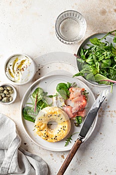 Homemade bagel sandwich with smoked salmon, cream cheese, capers and spinach for healthy breakfast top view