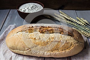 Homemade baked bread flour and wheat on light wooden background photo