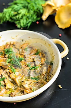 Homemade baked chanterelle mushrooms in frying pan isolated