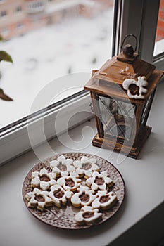 Homemade baked cookies with chocolate on a plate on white windowsill