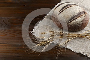 Homemade baked goods and ears of wheat on a wooden background.