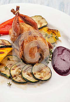 Homemade baked quails with grilled zucchini
