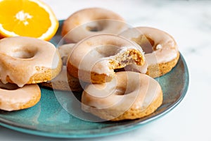 Homemade baked whole wheat vegan donuts with orange glaze