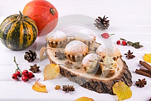 Homemade baking in autumn style. Delicious cupcakes on a wooden board with cinnamon sticks, anise stars, pumpkins