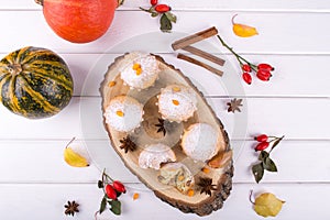 Homemade baking in autumn style. Delicious cupcakes on a wooden board with cinnamon sticks, anise stars, pumpkins and berries