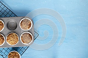 Homemade baking concept - fresh baked muffins on cooling rack, minimal picture, bright blue background, background, top view, copy