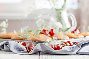 Homemade baking. Cupcakes with cherries.Dessert decorates with fresh berries and leaves. Wooden background. Food styling