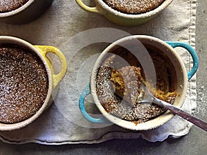 Homemade baking: gluten-free pumpkin custards in ramekins with spoon photo