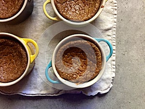 Homemade baking: gluten-free pumpkin custards in ramekins with spoon photo