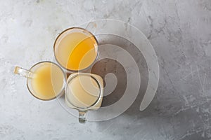 Homemade Beef Bone Broth in Glasses on a gray concrete background, top view with copy space