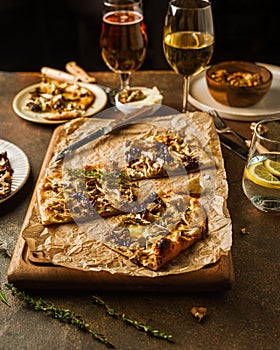 Homemade Belgian style mushroom pizza, flammekeuche, and wine and beer in glasses
