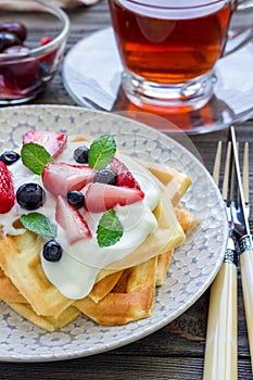 Homemade belgian waffles with yogurt, strawberry and blueberry, breakfast time