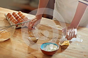 Homemade is always the best. a set of hands rolling out dough.