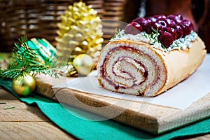 Homemade biscuit cherry roll with yoghurt cream and Christmas decoration