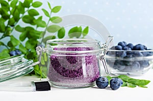 Homemade blueberry face and body sugar scrub/bath salts/foot soak in a glass jar. DIY cosmetics for natural skin care. Copy space. photo