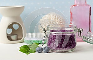 Homemade blueberry face and body sugar scrub, bath salts, foot soak in a glass jar. DIY cosmetics for natural skin care.