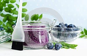 Homemade blueberry face and body sugar scrub/bath salts/foot soak in a glass jar. DIY cosmetics for natural skin care. Copy space.