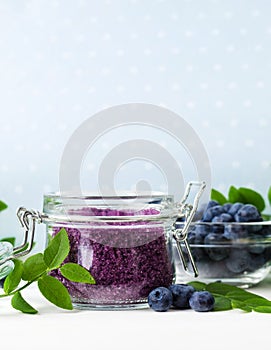 Homemade blueberry face and body sugar scrub/bath salts/foot soak in a glass jar. DIY cosmetics for natural skin care. Copy space.