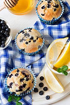 Homemade blueberry muffins with fresh berries, honey and lemon