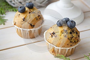 Homemade blueberry muffins made with organic ingredients, white shabby background.