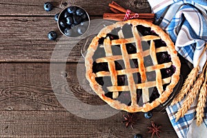 Homemade blueberry pie, top view table scene over a rustic wood background