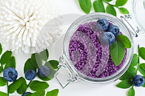 Homemade blueberry sugar scrub/bath salts/foot soak in a glass jar. DIY cosmetics for natural skin care. Copy space.