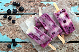 Homemade blueberry vanilla ice pops in a cluster on paper