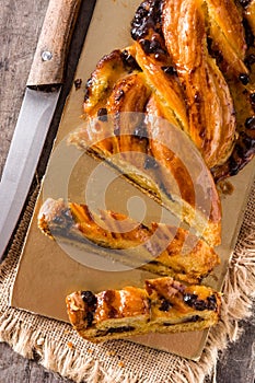 Homemade braid stuffed with chocolate and cut into pieces on wood