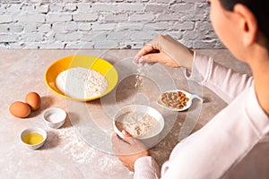 Homemade bread baking. closeup woman hands mixing ingredients for dough preparation in bright kitchen with marble countertop