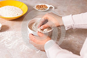 Homemade bread baking. closeup woman hands mixing ingredients for dough preparation in bright kitchen with marble countertop