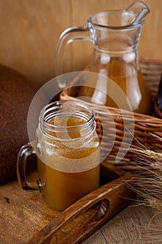 Homemade bread kvass. Summer carbonated soft drink. Glass and carafe on a wooden table. Black Overseas Rye Bread - Ingredients for